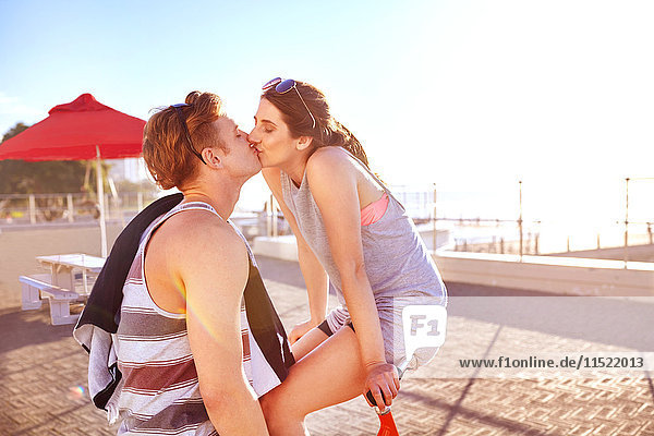 Paar auf Promenade auf Fahrrädern beim Küssen