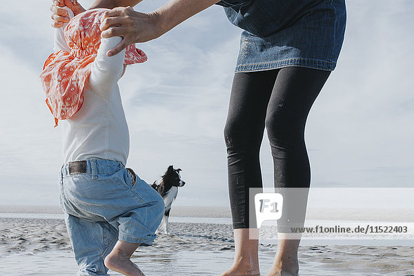 Niederlande  Schiermonnikoog  Mutter mit kleiner Tochter und Hund am Strand