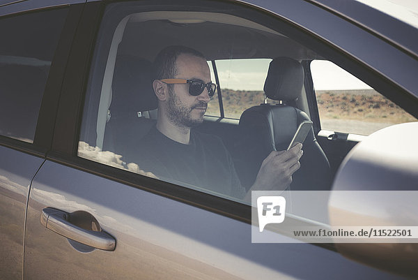 Man in a car with smartphone
