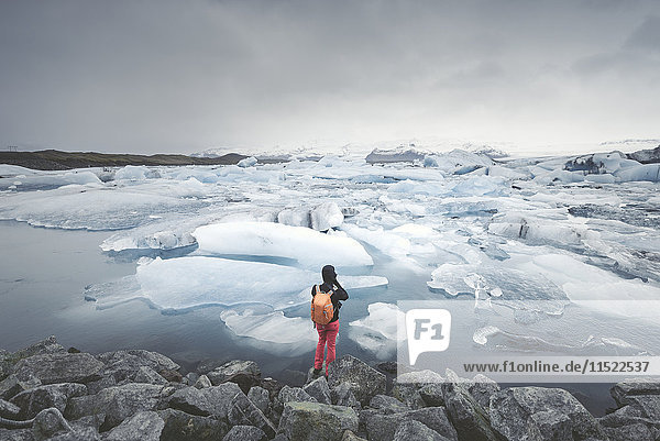 Iceland  view of Joekulsarlon  glacial river lagoon with man standing in the foreground