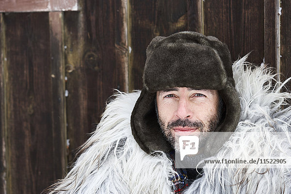 Portrait of man wearing fur cap in winter