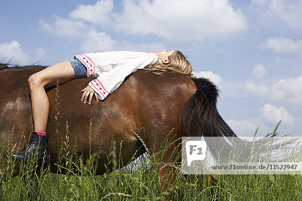 Mädchen auf einem Pferd liegend