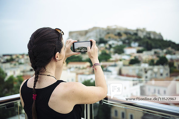 Griechenland  Athen  Frau beim Fotografieren des Parthenon-Tempels in der Akropolis  umgeben von der Stadt.