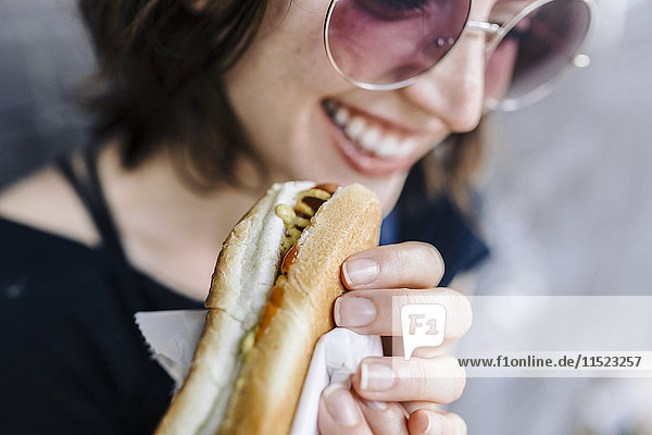 Lächelnde Frau mit Hot Dog  Nahaufnahme
