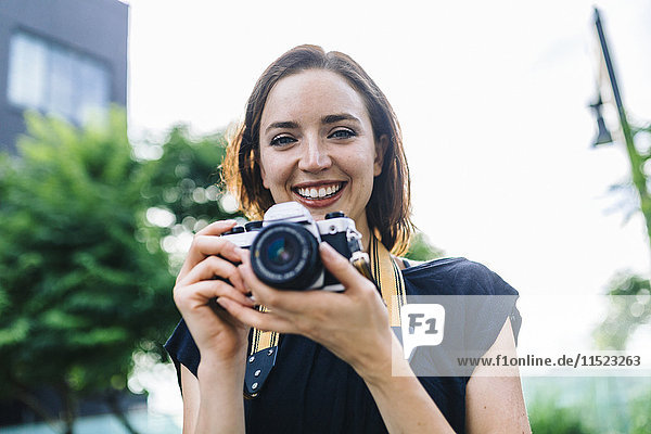 Porträt einer lächelnden Frau mit Kamera