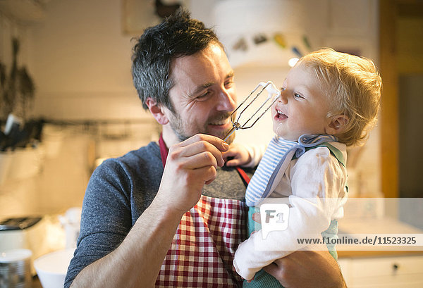 Father and baby boy in kitchen baking a cake