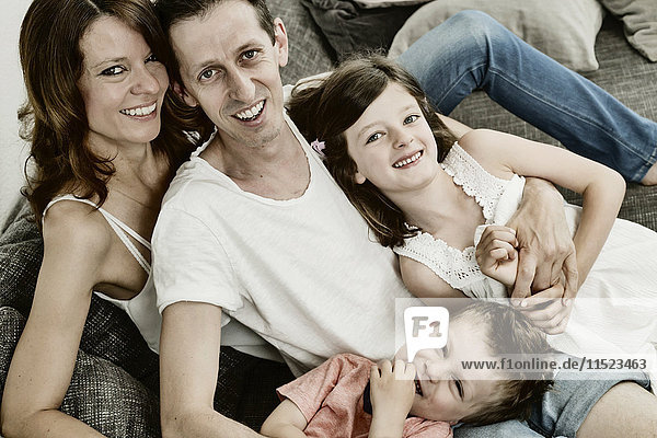 Happy family sitting at home on couch