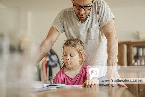 Vater prüft Hausaufgaben seiner Tochter