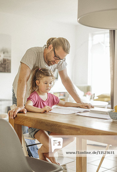 Father checking homework of his daughter