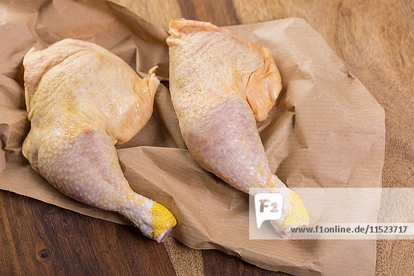 Two chicken legs on brown paper  close-up