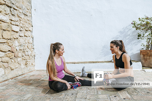 Zwei junge Frauen Dong Dehnübungen auf der Straße