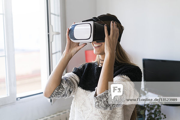 Young woman wearing VR glasses at home