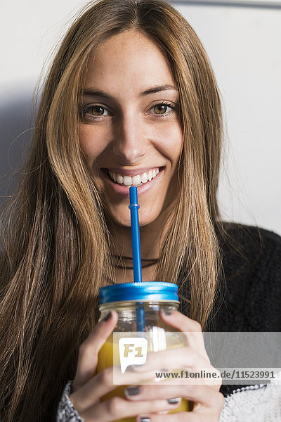 Portrait of smiling young woman drinking homemade drink