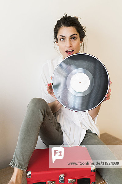 Porträt einer Frau mit Schallplatte und Plattenspieler