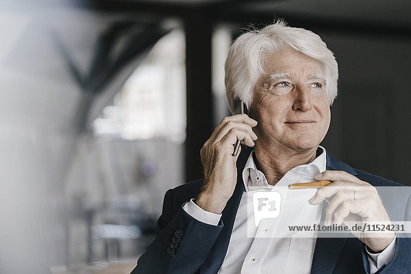 Porträt eines entspannten Senior Geschäftsmannes am Telefon