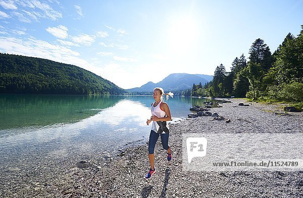 Germany  Bavaria  Young woman jogging at Lake Walchensee