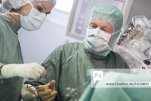Operationsschwester bei der Instrumentenübergabe während einer Operation