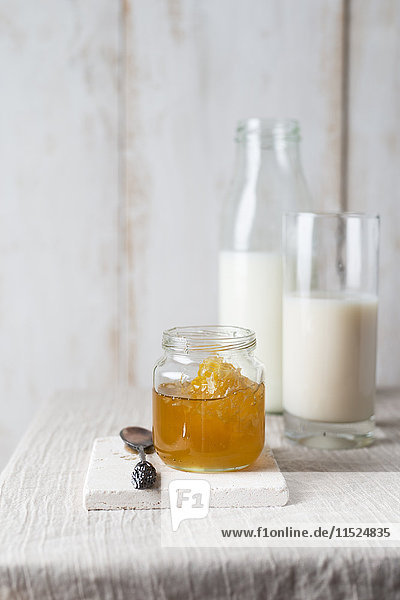 Honigglas mit Wabe und Milch