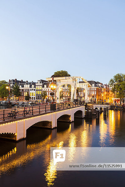 Netherlands  Amsterdam  view to Magere Brug with Amstel River in the foreground at evening twilight