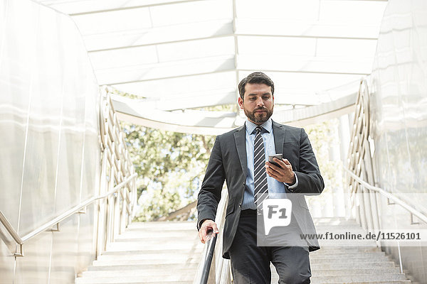 Businessman on the move looking at cell phone