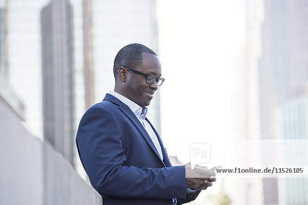 Businessman checking cell phone outdoors