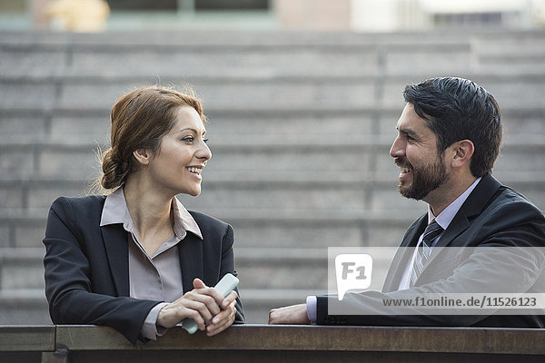 Businesswoman and businessman talking outdoors
