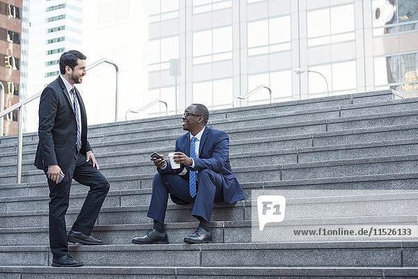 Two businessmen talking on stairs