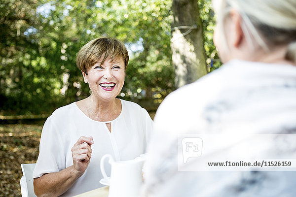Happy senior woman socializing with friend outdoors