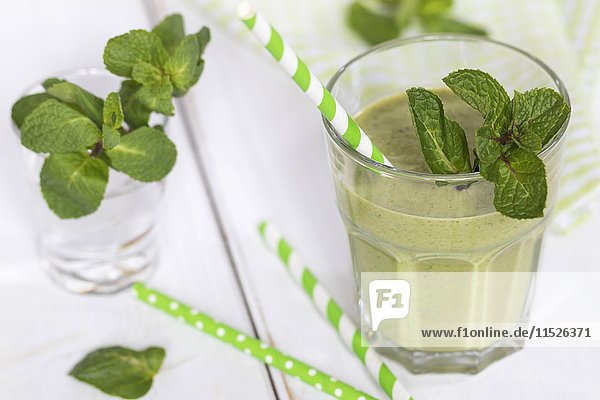 Glas grüner Smoothie mit Minzblättern garniert