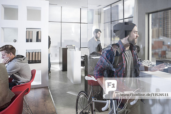 Casual man with bike in modern office