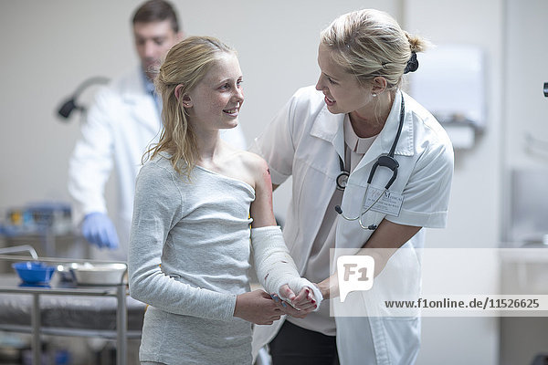 Arzt im Gespräch mit verletztem Mädchen im Krankenhaus