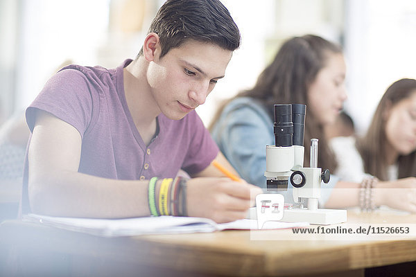 Student der Naturwissenschaften im Unterricht mit dem Mikroskop