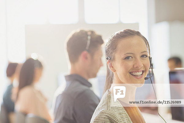 Portrait smiling female telemarketer wearing headset in office
