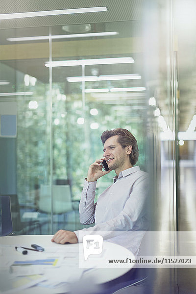 Businessman talking on cell phone in conference room