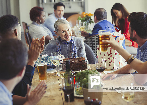 Frau genießt Geburtstag mit Freunden am Restauranttisch