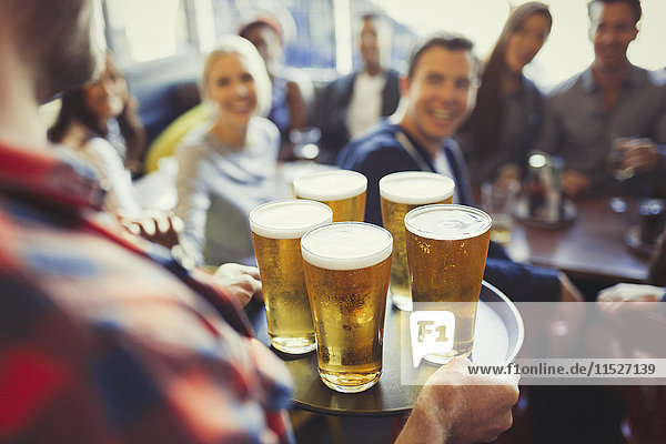 Barkeeper Serviertablett mit Bier an Freunde in der Bar