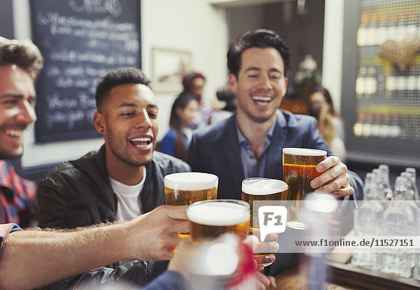 Männer Freunde toasten Biergläser an der Bar
