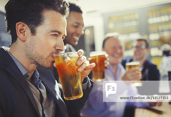 Man drinking beer with friends at bar