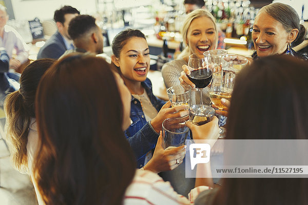Enthusiastische Freundinnen beim Feiern  Trinken von Bier und Weingläsern in der Bar
