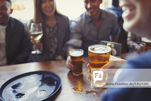 Freunde trinken Bier und Wein am Tisch in der Bar