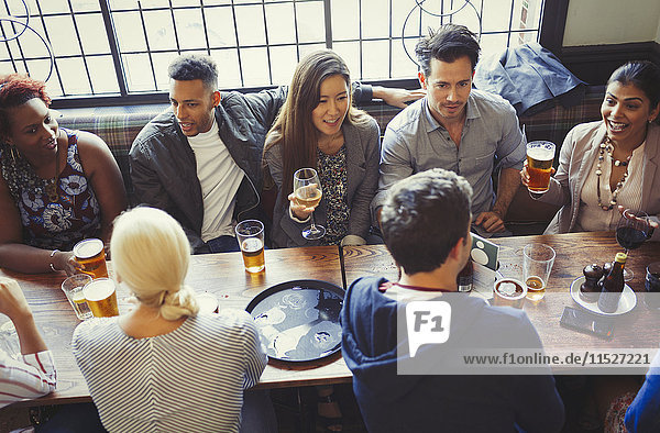 Overhead view of friends drinking beer and wine at table in bar