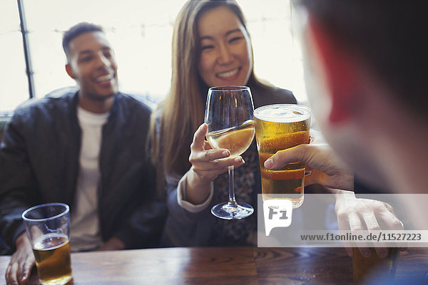 Freunde feiern  rösten Bier und Wein bei Tisch in der Bar