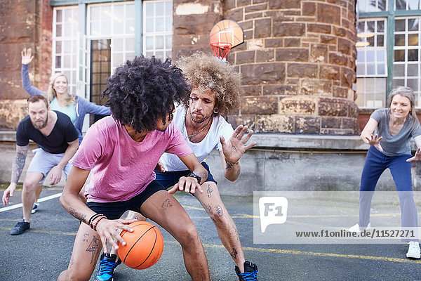 Freunde beim Basketball auf dem städtischen Basketballplatz