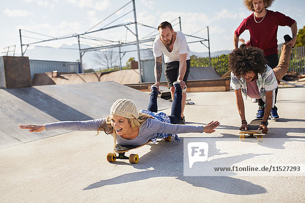 Verspielte Freunde auf Skateboards im sonnigen Skatepark