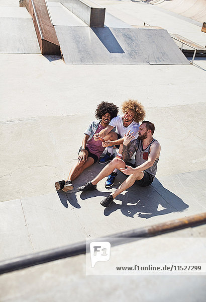 Overhead-Ansicht männliche Freunde  die Selfie mit Fotohandy im sonnigen Skatepark nehmen