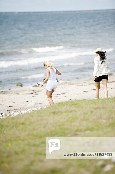 Zwei junge Frauen gehen am Strand spazieren