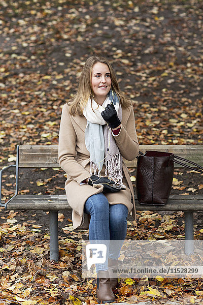 Lächelnde Frau auf einer Bank sitzend