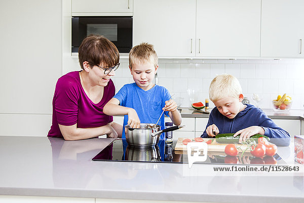 Jungen bereiten in der Küche Essen zu