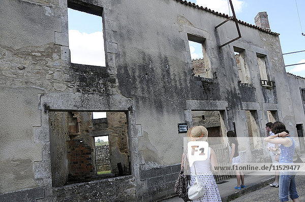 Frankreich  Limousin  Haute-Vienne (87)  Oradour-sur-Glane  Besucher vor den Ruinen des Märtyrerdorfes  wo 642 Menschen im Zweiten Weltkrieg von Nazi-Soldaten der Waffen-SS ermordet wurden.