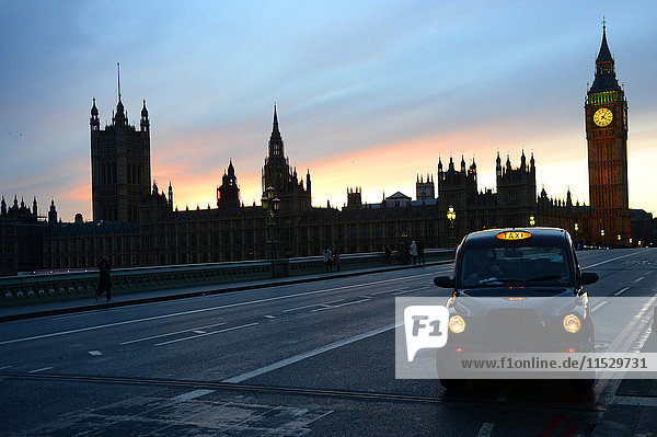 United Kingdom  London  a taxi in the foreground  Big Ben and the Parliament from Westminster Bridge in the background